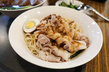 Chinese Taiwanese style boiled egg port soy sauce dry stirred noodles in a white plate 