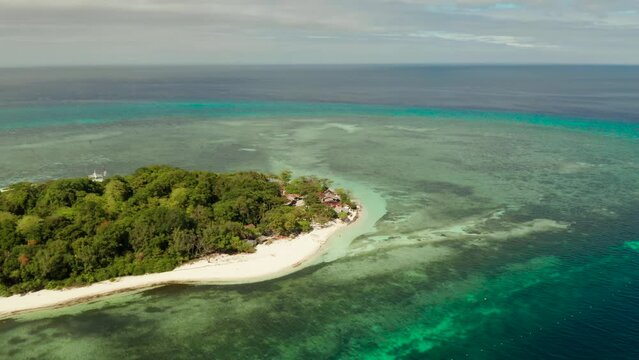 Tropical island Mantigue and sandy beach surrounded by atoll coral reef and blue sea, aerial view. Small island with sandy beach. Summer and travel vacation concept, Camiguin Philippines Mindanao