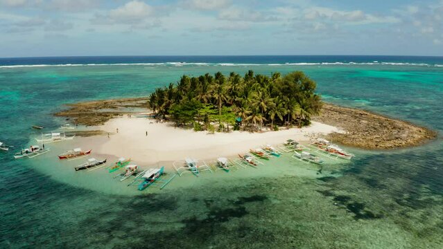 Travel concept: sandy beach on a small island by coral reef atoll from above. Guyam island, Philippines, Siargao. Summer and travel vacation concept.