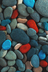 Black, red and turquoise pebbles, stone background.
