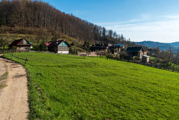 Fototapeta na wymiar Small settlement with few wooden houses in mountains in Slovakia - Kycera settlement in Javorniky mountains