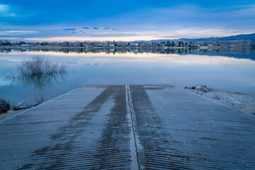 dusk over boat ramp and calm lake in Colorado foothills of Rocky Mountains, Boedecker Reservoir in early spring - 778400122