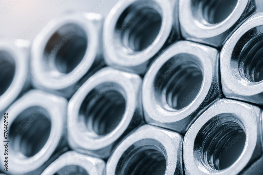 Poster A close up of many nuts and bolts. The nuts and bolts are all the same size and are arranged in a row