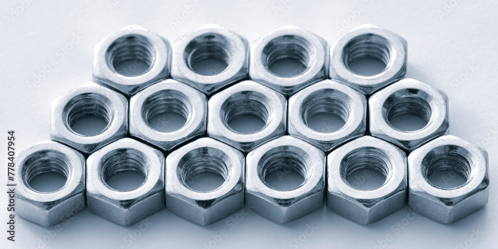 Aufkleber A close up of many nuts and bolts. The nuts and bolts are all the same size and are arranged in a row