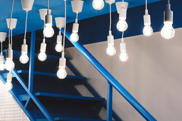 A staircase with a blue railing and a blue wall. The railing is lit up with many white lights