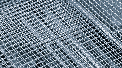 A close up of a metal mesh with a silver color. The mesh is made of metal and has a pattern