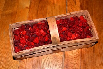 A basket of sweet raspberries is on the table