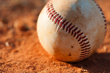 Close Up of Dirty Baseball on Red Dirt Infield