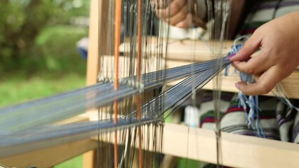 Woman Weaves a Blue Garter on a Loom. Weaving is a Method of Textile Production in Which Two Sets of Yarns are Interlaced to Form a Fabric or Cloth.