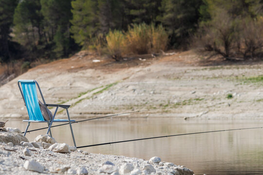 Cañas de pescar y silla preparada para una larga jornada de pesca en el pantano de Beniarres, España