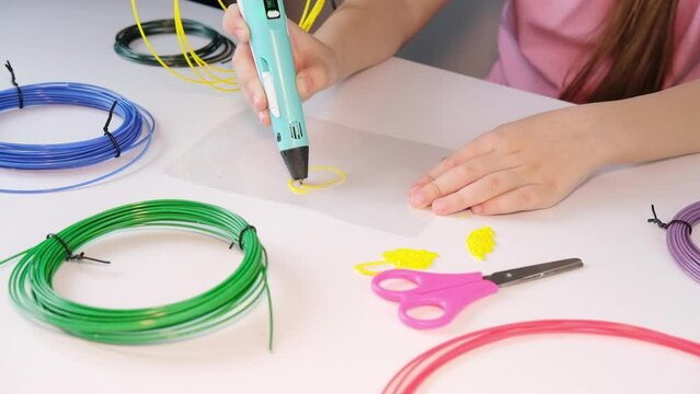 3D printable pen, hands holding colorful toy. Colored plastic in rolls. STEM education. Play and learn at school and at home. New toy for child.	