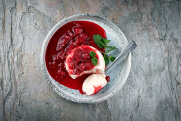 Traditional quark mousse with rhubarb and raspberry compote served as top view on a Nordic Design...