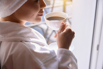 Adult female enjoying her morning coffee on balcony