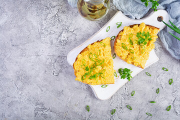 Scrambled eggs with herbs and toasts. Delicious breakfast with eggs and herbs. Top view