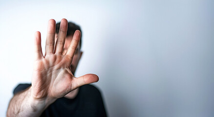 Obraz premium A man making a stop gesture with his hand against a white background. Copy space.