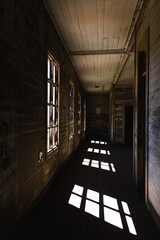 hallway in abandoned house, with light coming through the windows