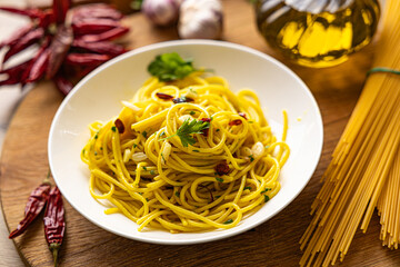 A plate of spaghetti aglio e olio with chili flakes, fresh parsley, garlic, and a drizzle of extra virgin olive oil