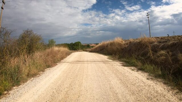 Via Francigena - gravel road on a summer day entering Torrenieri, Montalcino, Province of Siena, Tuscany, Italy