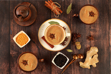 Indian masala chai tea with milk, ginger, anise and cinnamon on an old wooden table. Traditional drink with spices, cafe concept, advertising for restaurant and menu.