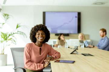 Confident young African American businesswoman smiling during a creative brainstorming session in a...