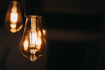 Warm light bulb hanging on dark background