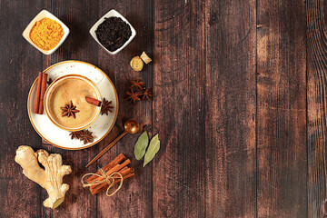 Traditional drink with spices,Indian masala chai tea with milk, ginger, anise and cinnamon on an old wooden table. cafe concept, advertising for restaurant and menu.