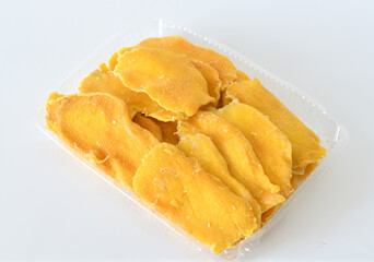 Dry mango in a plastic container on a light background