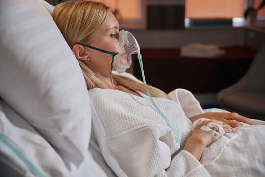 Hospitalized adult woman receiving intravenous therapy in inpatient facility