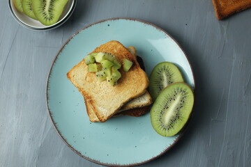 Kiwi bread on plate on grey background with space for text. Healthy breakfast with fruit