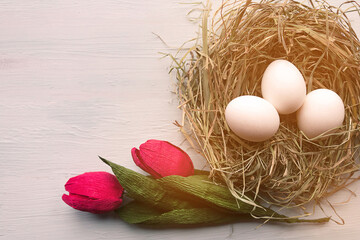 Eggs in the nest and tulips. Beautiful Easter greeting card
