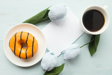 Donut and coffee cup on wooden background, top view