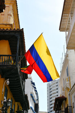Bandera Colombiana en medio de la calle y edificios.