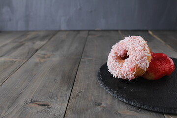 Round donuts donuts with white coconut sprinkles on grey background with space for copy space text. Donut Day