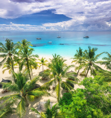 Aerial view of white sandy beach with palm trees, umbrellas, yachts, boats, blue ocean, sky with clouds at sunset. Summer vacation in Kendwa, Zanzibar island. Tropical landscape. Clear sea. Top view - 778510706