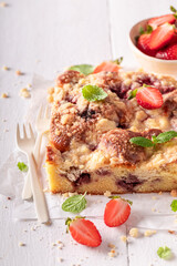Homemade and tasty strawberry yeast cake with crumble and fruits.