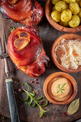 Aromatic roasted pork knuckle served with sauerkraut and potatoes. - obrazy, fototapety, plakaty