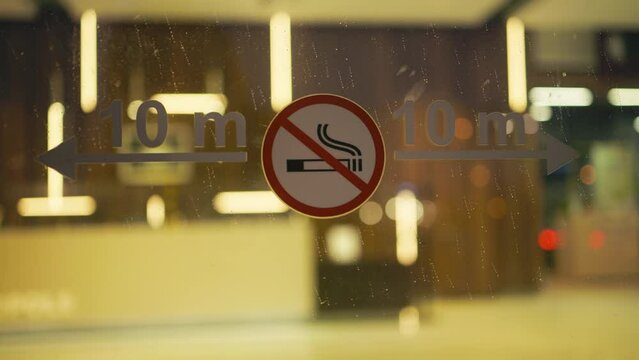 Evening display: No smoking sign on a window in a shop