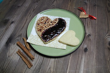 heart shaped chocolate and glaze ginger cake on plate on wooden table