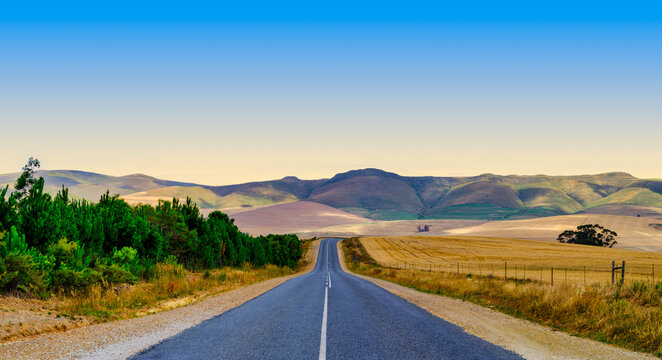 Panorama shot of R45 road through beautiful overberg countryside after harvest at sunset, Western Cape, South Africa