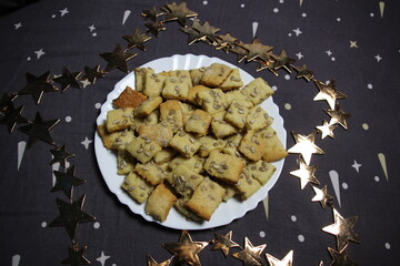 Christmas cookies on a plate with star decoration on black background