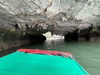Halong Vietnam 3-14-2024 - Tour boats approaching the many cave mouths at low tide, to a private calm lake at Halong Bay