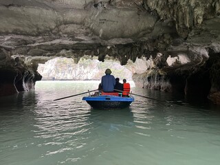 Halong Vietnam 3-14-2024 - Tour boats approaching the many cave mouths at low tide, to a private calm lake at Halong Bay