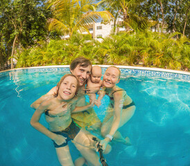 A happy family of four, parents and two sons, shares joy and laughter while enjoying a refreshing day at the pool, creating treasured memories together