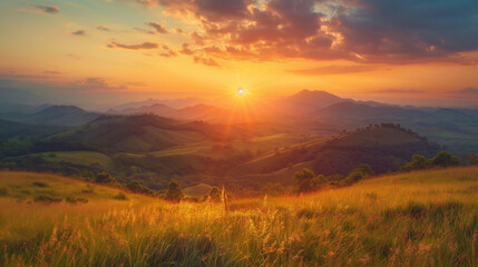 A beautiful sunset over a mountain range with a bright sun in the sky
