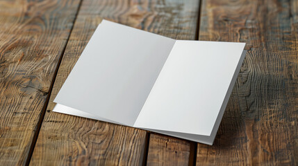 A white open blank paper on a wooden table. The card  folded, open, A4 paper manu, greeting card mockup sitting on a wooden table with empty space for text and logo.