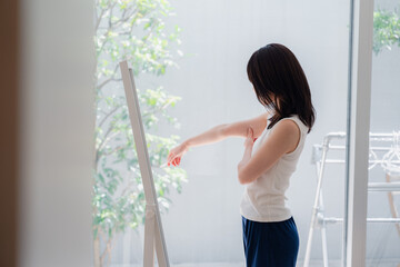 自分の体型を気にする若い女性