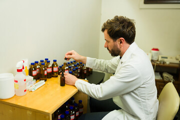 Homeopathic doctor preparing the formula medicine - obrazy, fototapety, plakaty