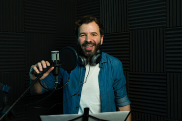 Happy male voice actor recording in studio