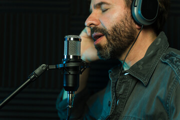 Male vocalist recording in studio