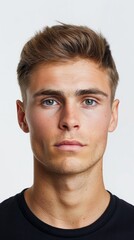 Obraz premium Modern Masculinity: Casual Male Portrait. Studio portrait of a young man with styled hair and a black shirt, exuding casual confidence.